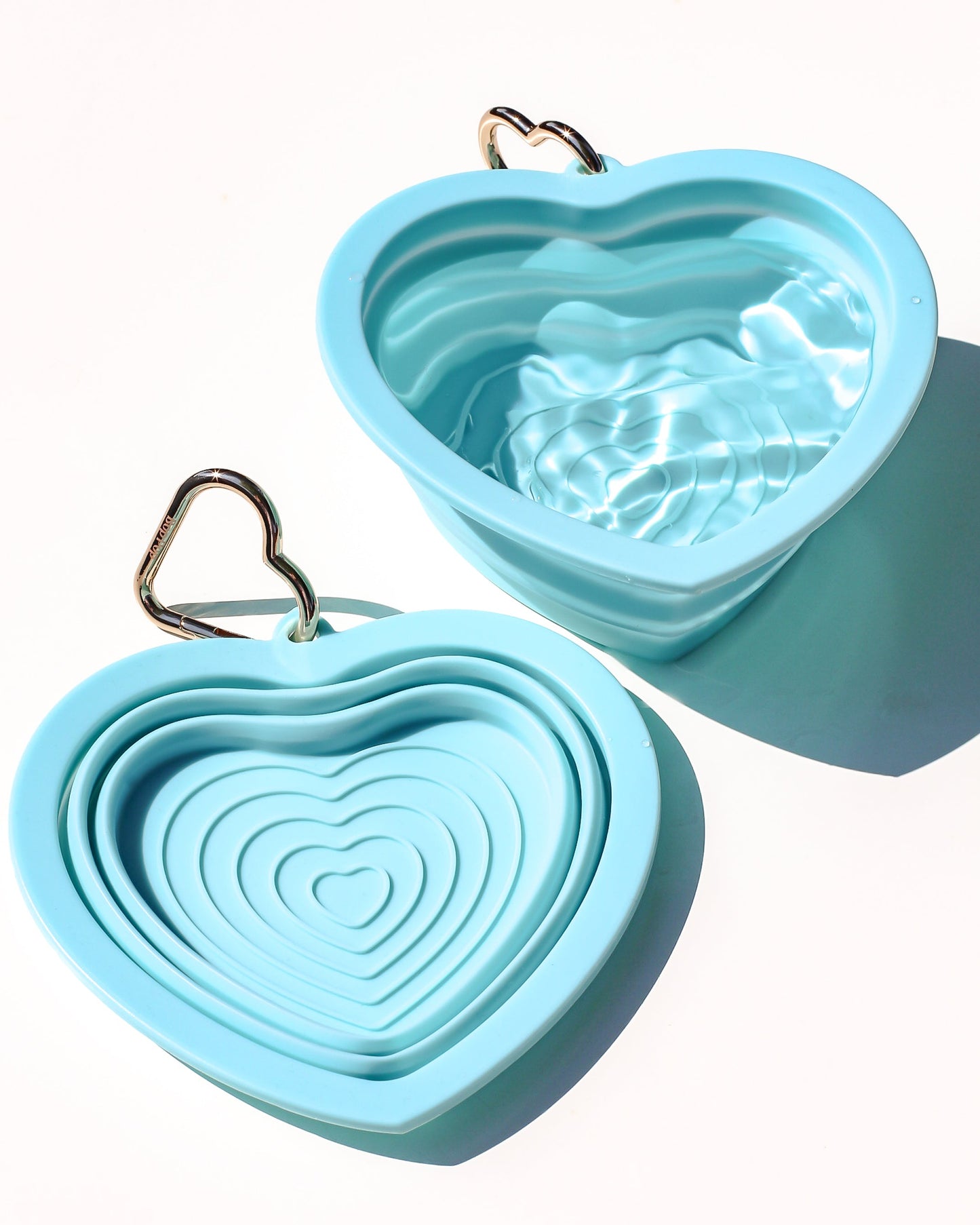 Collapsible portable aqua blue pet water or food bowl. Silicone and lightweight for cafe or travel. Gold heart carabiner by Bop Pop Pets. Aqua or blue lagoon color luxury style and elevated water bowl.