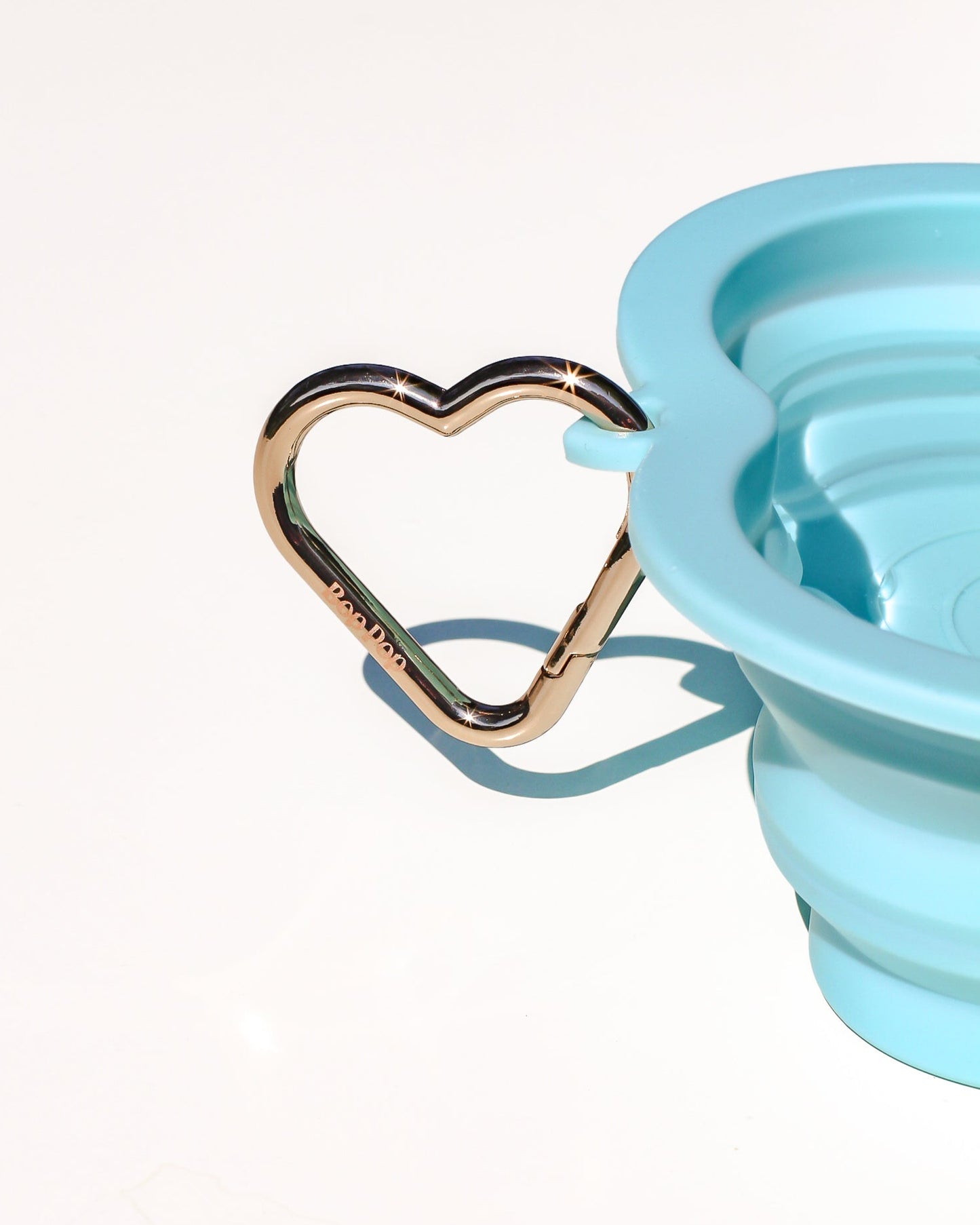 Collapsible blue silicone water bottle with heart-shaped carabiner with light gold alloy metal steel