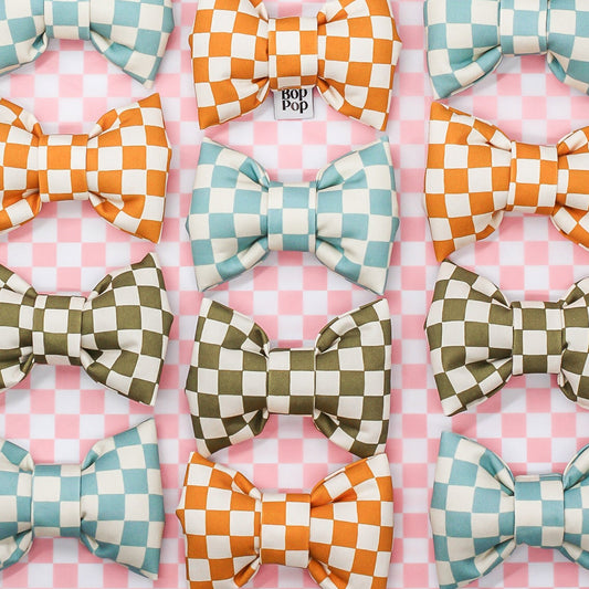 Set of colorful checkered bows on a pink and white checkered background
