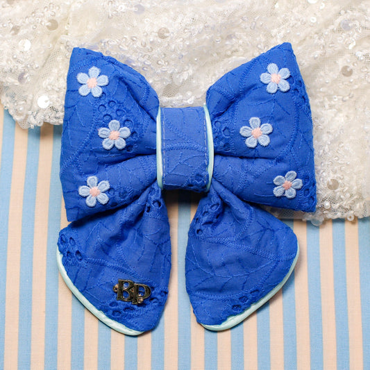 Blue bow with white floral patterns on a striped background
