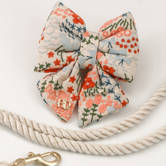 Luxury dog bows for collars.
Celebration Sailor bow tie dog cats embroidery fabric and gold label tag. High quality luxurious premium handmade pet accessory. Dog gift Sailor bow bop pop pets Beige Buff Natural Linen with floral flowers in coral, peach, olive, teal and light blue. Wedding bows for dogs
