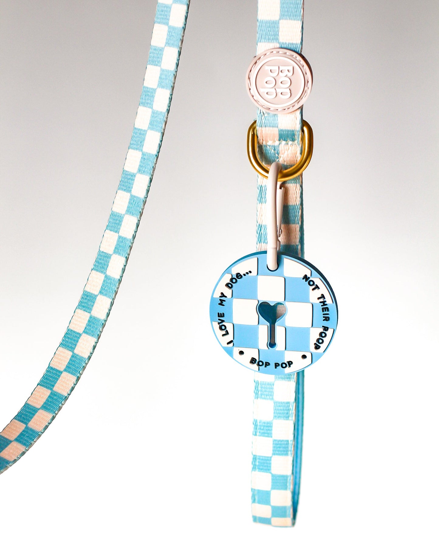 Poop Loop in blue checkered with heart design key hole opening for used dog waste bags and dog walks by Bop Pop Pets