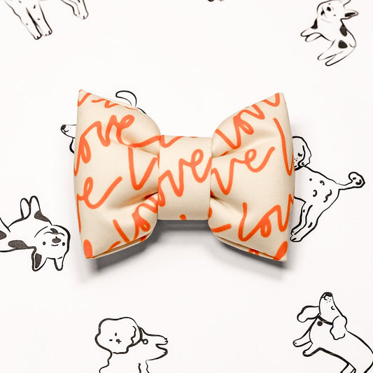Love Text White bow tie with orange text on a checkered orange and white background. Bop Pop Pets accessories