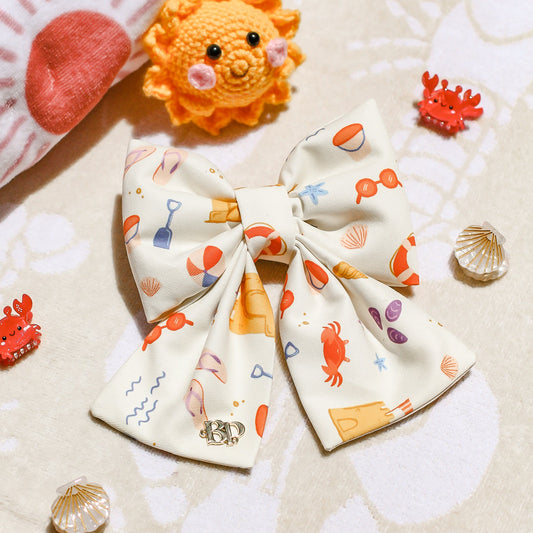 Colorful dog bow with ocean-themed design on a textured surface. Bop Pop Pets for trendy dogs and cats