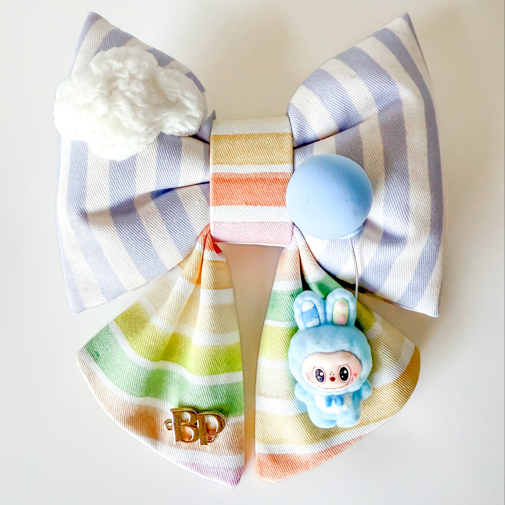 Large decorative bow with striped pattern and cartoon character on a white background