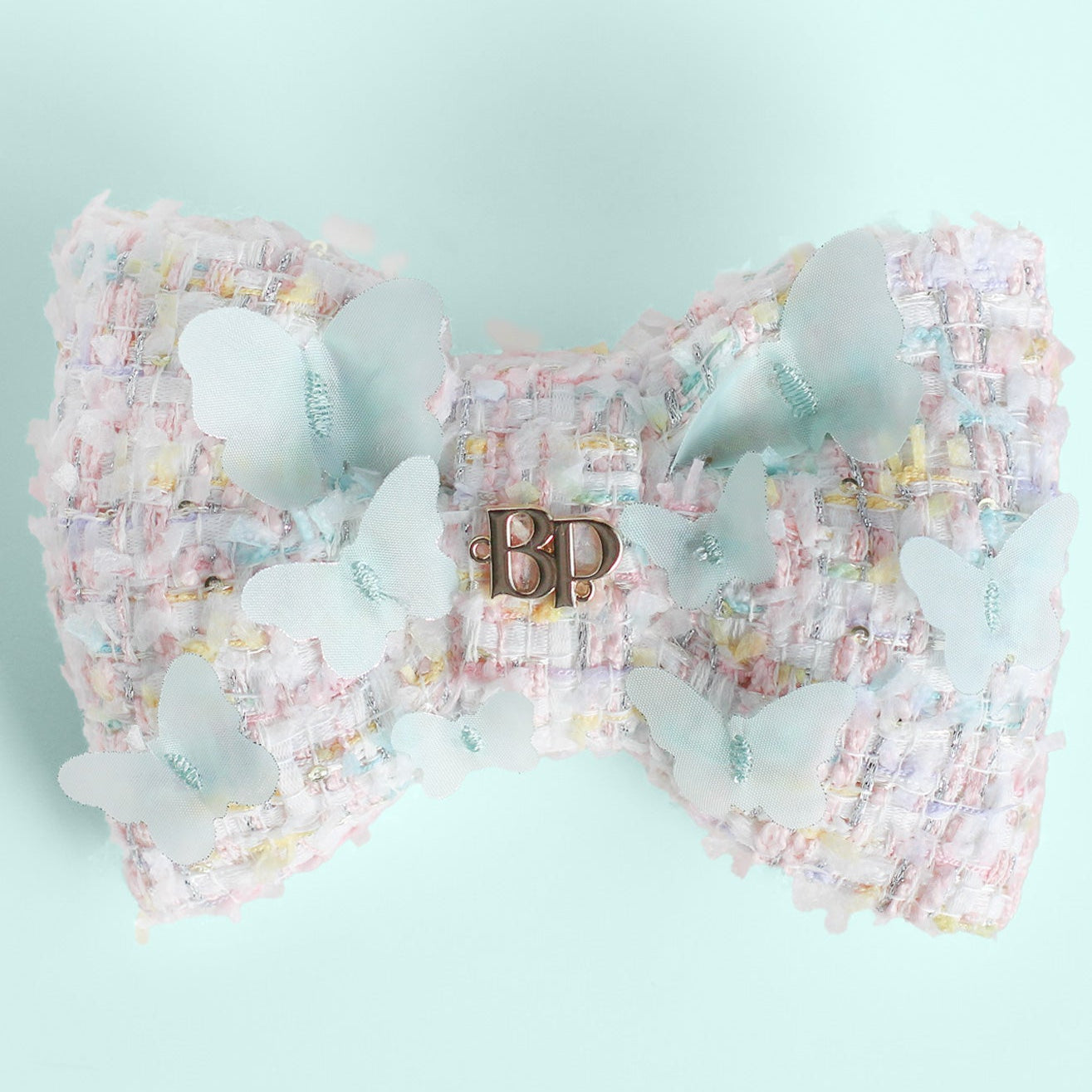 Large decorative bow with floral pattern and 'BP' initials on a light blue background
