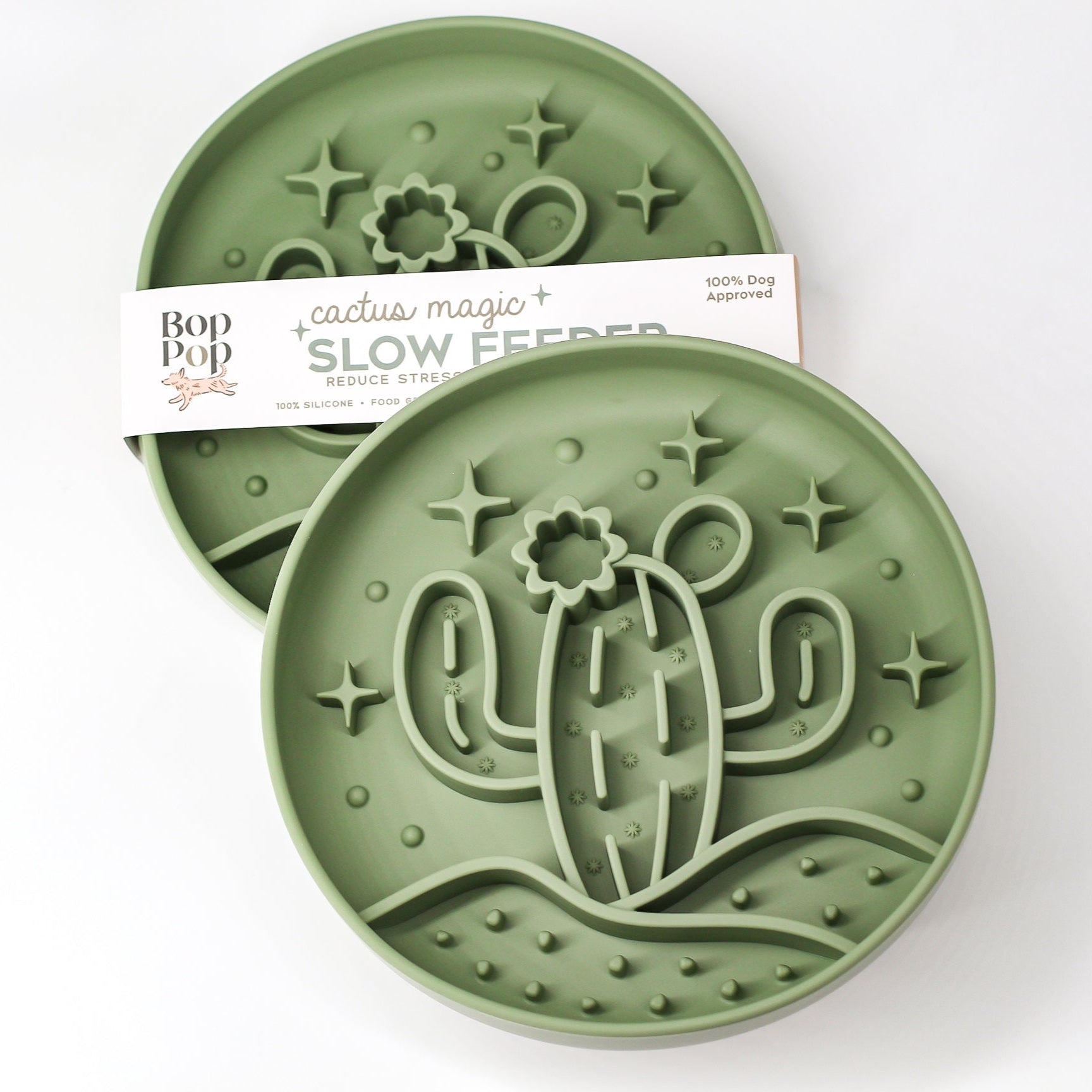 Cactus Magic Slow Feeder staggered on white background with upper left feeder displaying brand packaging labeled 'Cactus Magic SLOW FEEDER' and lower right feeder displaying 3 dimensional pattern of a cactus with blooming flower in the desert hill with 5 stars in sage green color.
