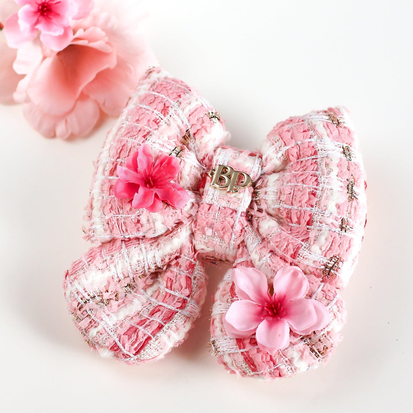 Pink floral hair accessories with a decorative bow on a white background
