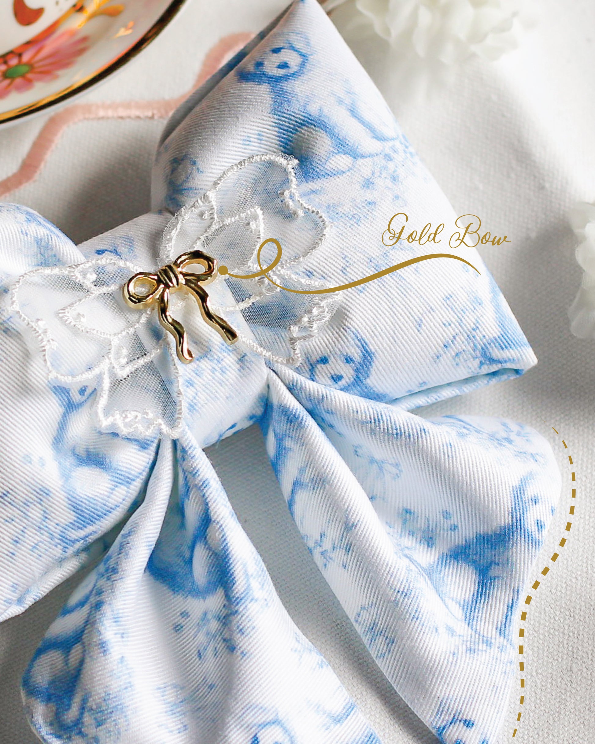 White and blue fabric bow with gold accents on a white background