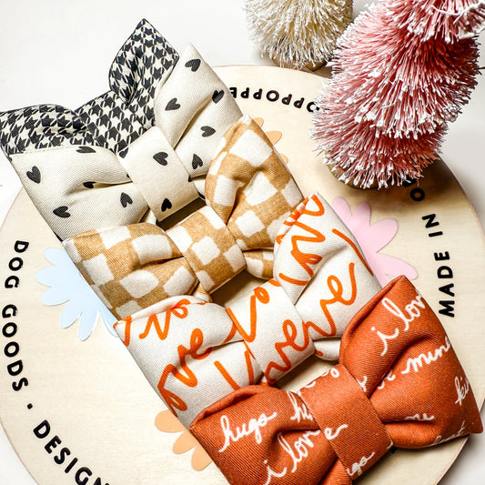 Collection of dog bows with text on a circular wooden board with decorative elements.