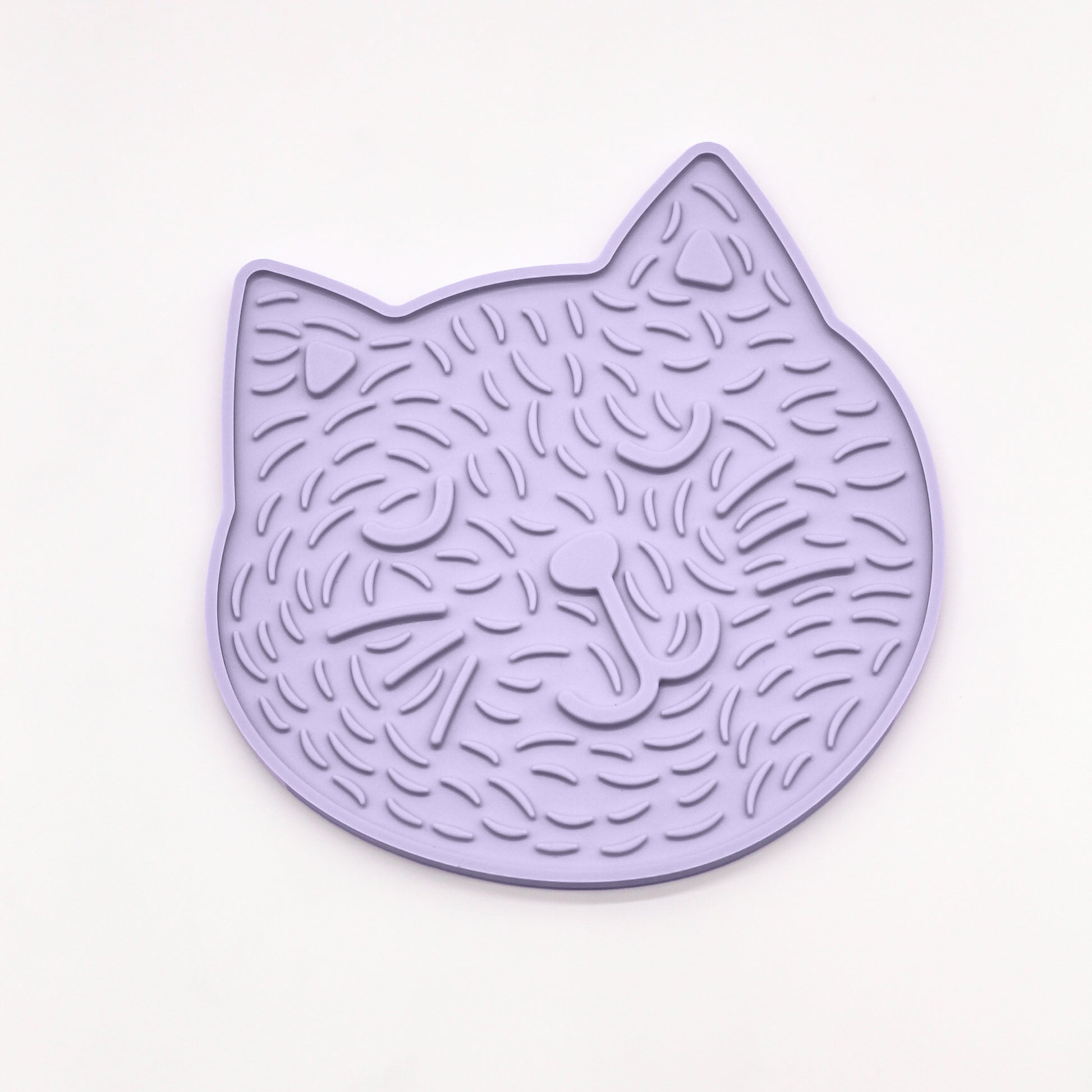 Happy Cat Kitty Lick mat for dogs cats kittens to reduce stress anxiety boredom Slow feeder shows a cartoon cat image on a lick mat with closed eye, smiling cat with ears and raised markings for fur details.