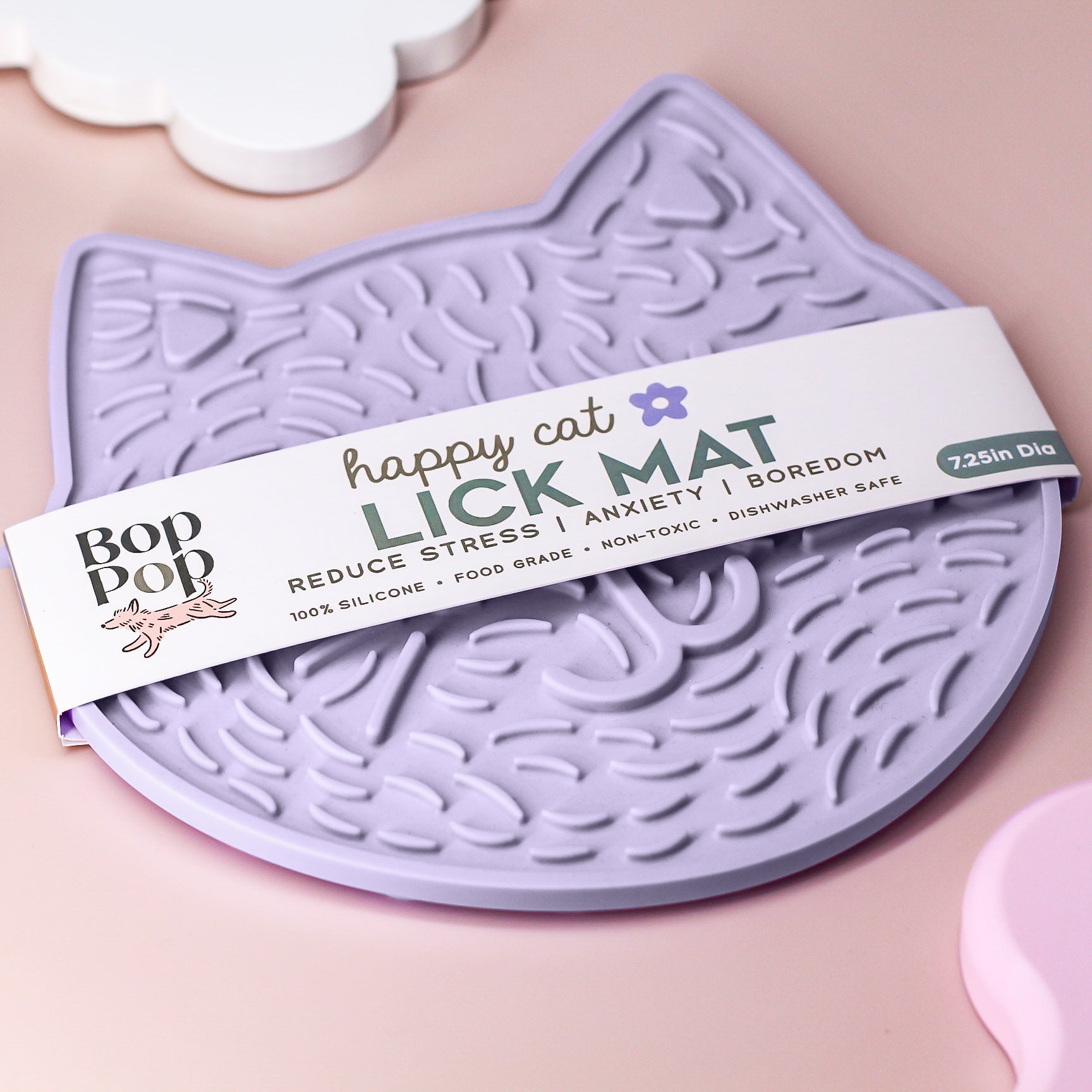 Happy Cat Kitty Lick mat packaging on a blush colored background displaying rectangular paper wrap labeled "Happy Cat LICK MAT" under the Bop Pop Brand with a peach colored dog icon.