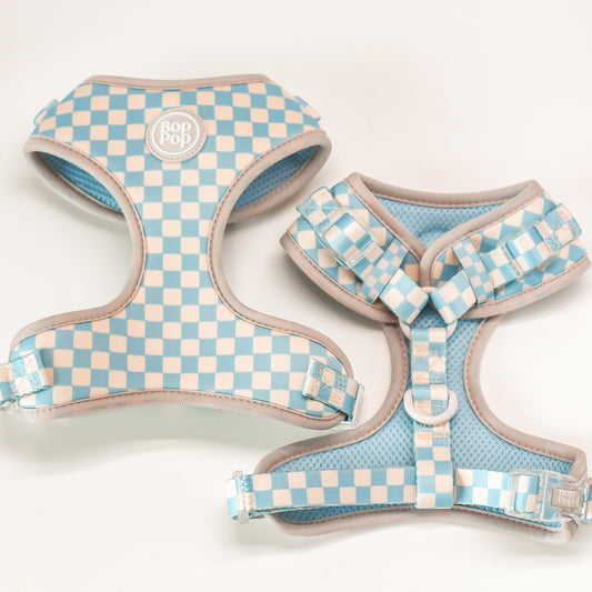 Two checkered dog harnesses on a light background