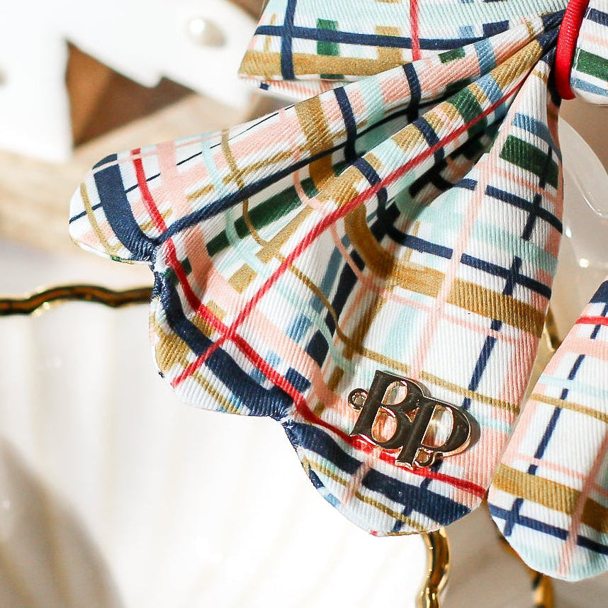 Plaid bow with gold plated heart metal buttons with decorative items. Holiday dog bows for premium handmade dog goods. Bop Pop Pets scalloped bows. Red satin piping trim for festive style