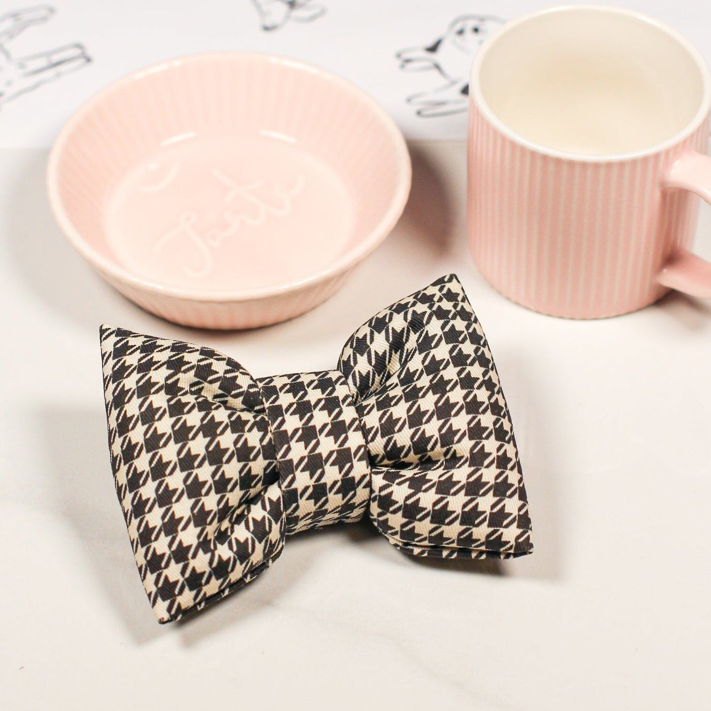 Pink ceramic bowl and espresso cup with a houndstooth cotton pet bow tie. Bop Pop Pets pet accessory.