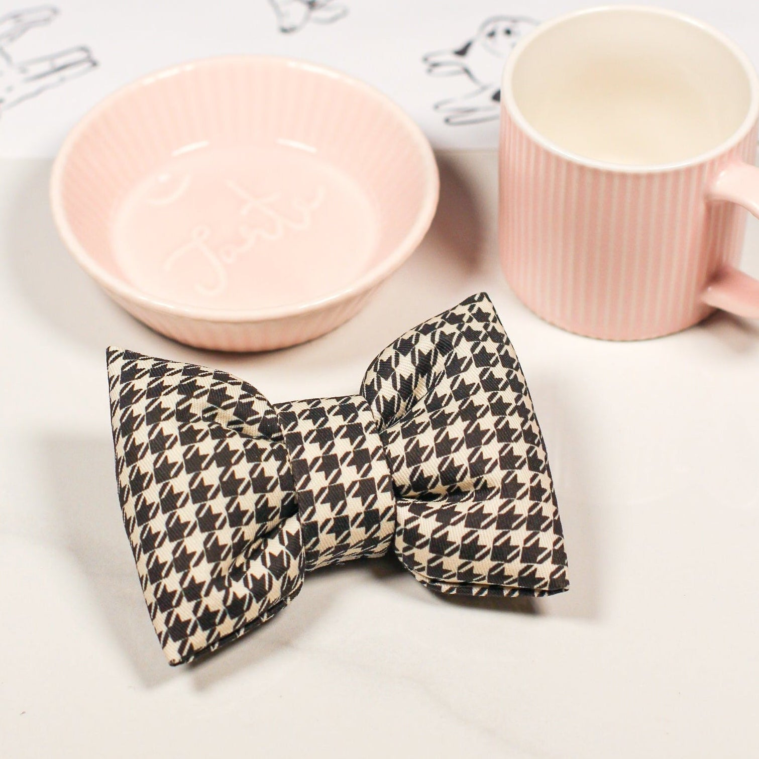 Pink ceramic bowl and espresso cup with a houndstooth cotton pet bow tie. Bop Pop Pets pet accessory.