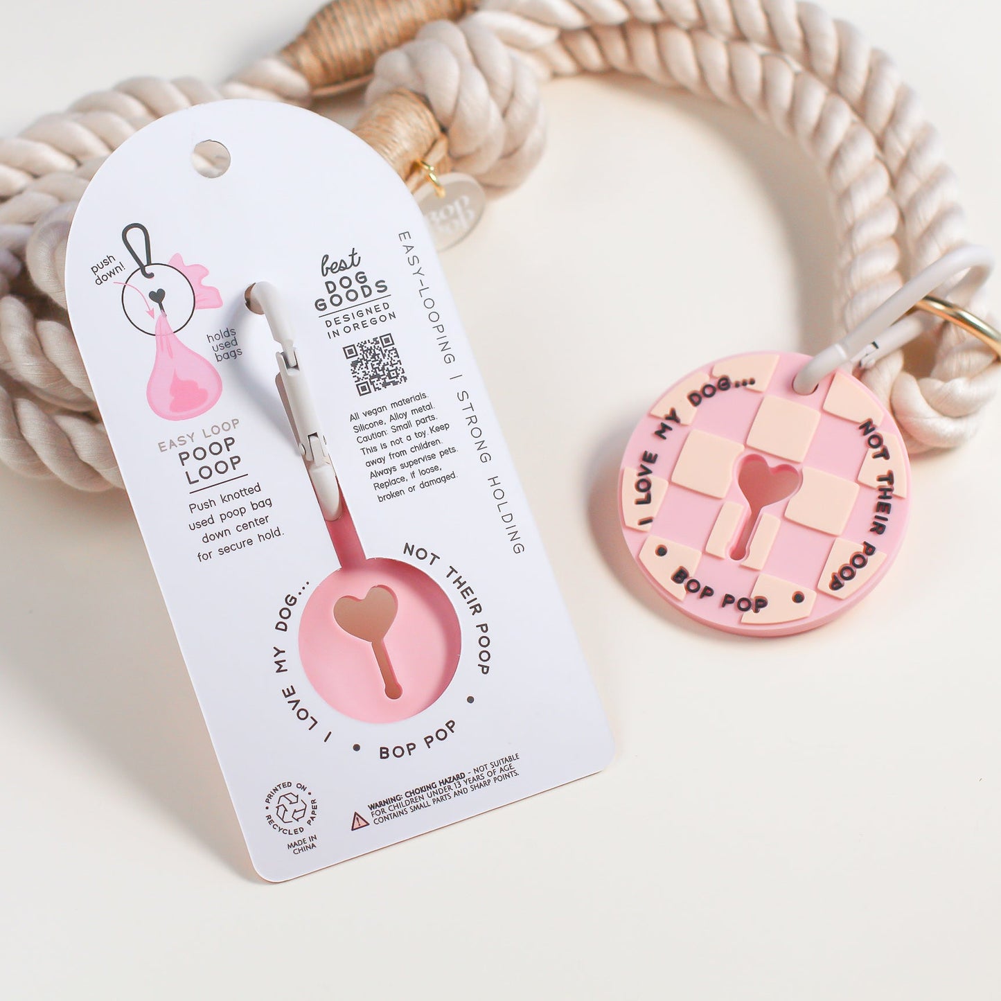 Dog leash with pink checkered poop loop with carabiner design on a white background