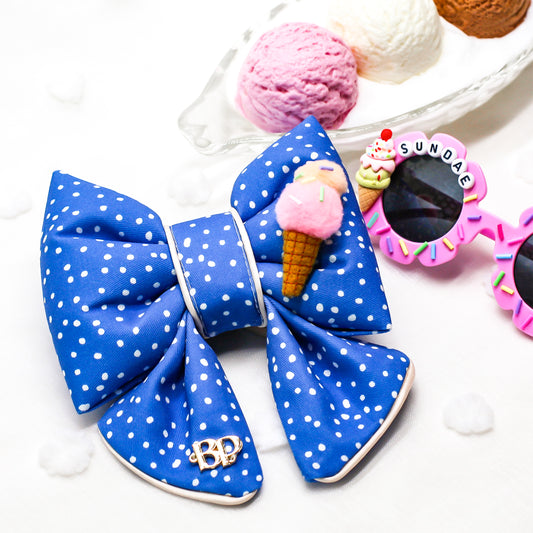 Blue polka dot bow with ice cream cone design on a white background