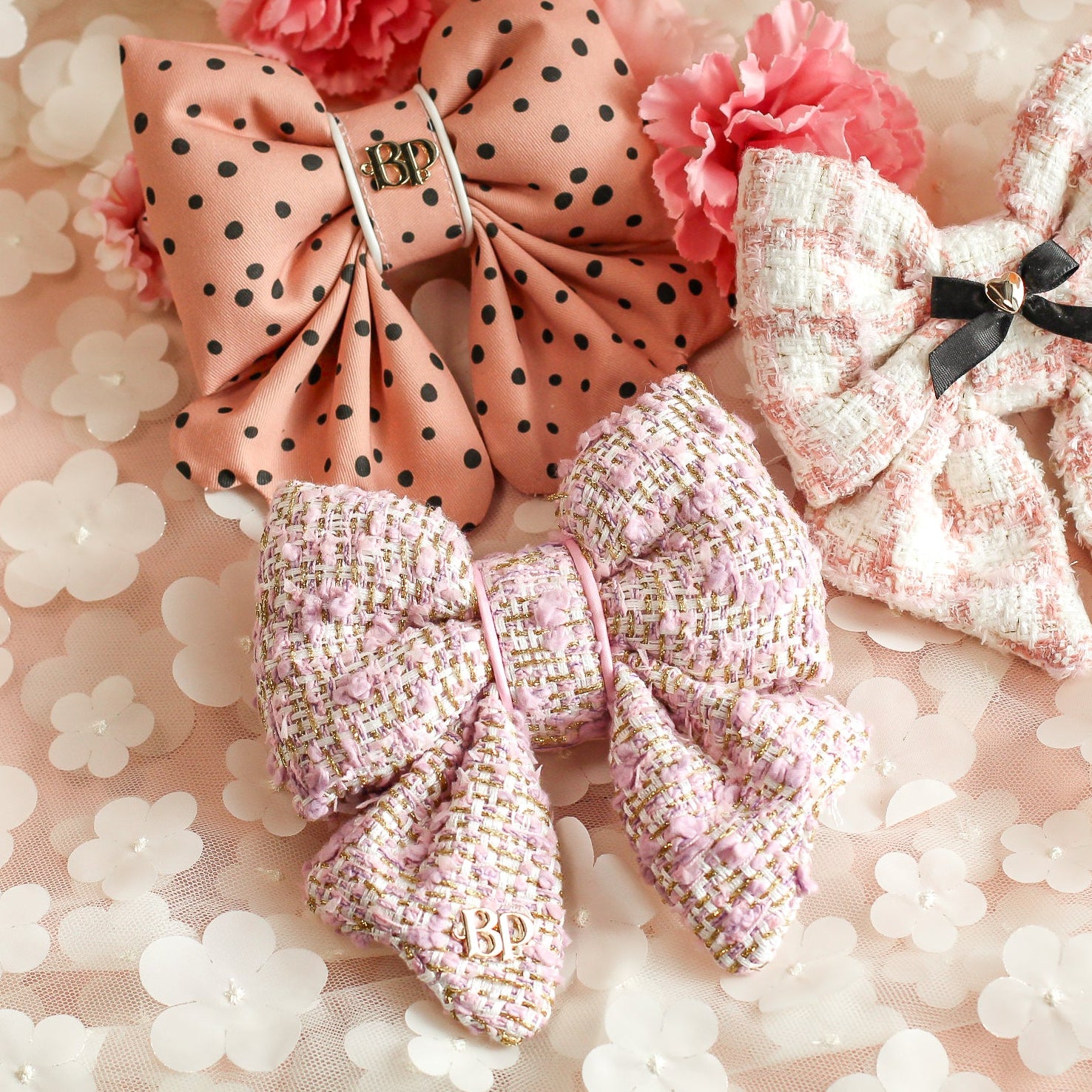 Set of decorative bows on a floral background. Polka dot and pink lilac tweed sailor bow for dogs cats in a textured tweed with gold threading. Bop Pop pets pet accessory.