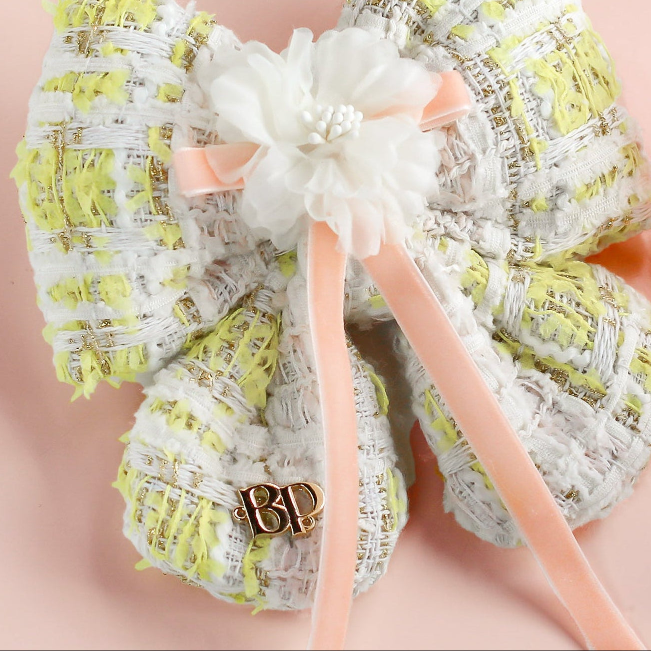Decorative headband with a bow on a pink background with Easter eggs and flowers.