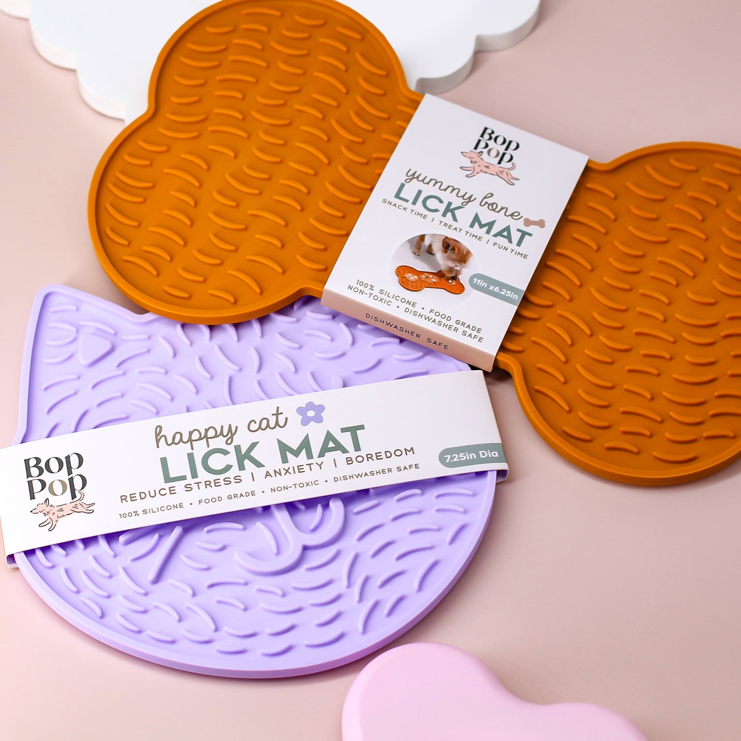 Bone and Cat Lick Mat displayed for the Dogs and Cat Collection by Bop Pop Pets featuring the brand's paper wrap packaging detailing LICK MAT title and suggested usage for Snack time, treat time for Fun Time and size dimensions. Including benefits of product and pet enrichment.