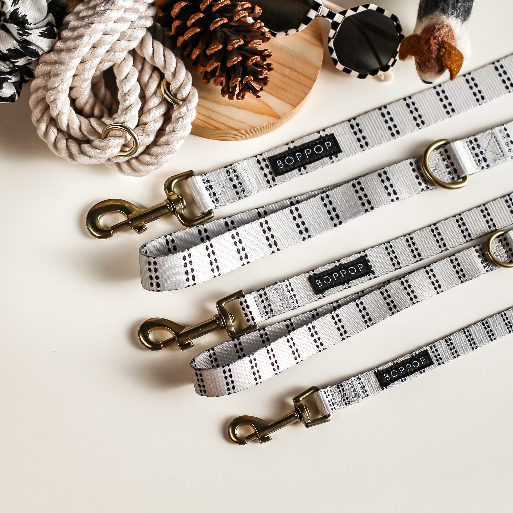 Dog leashes with branded clasps on a light surface with decorative items.