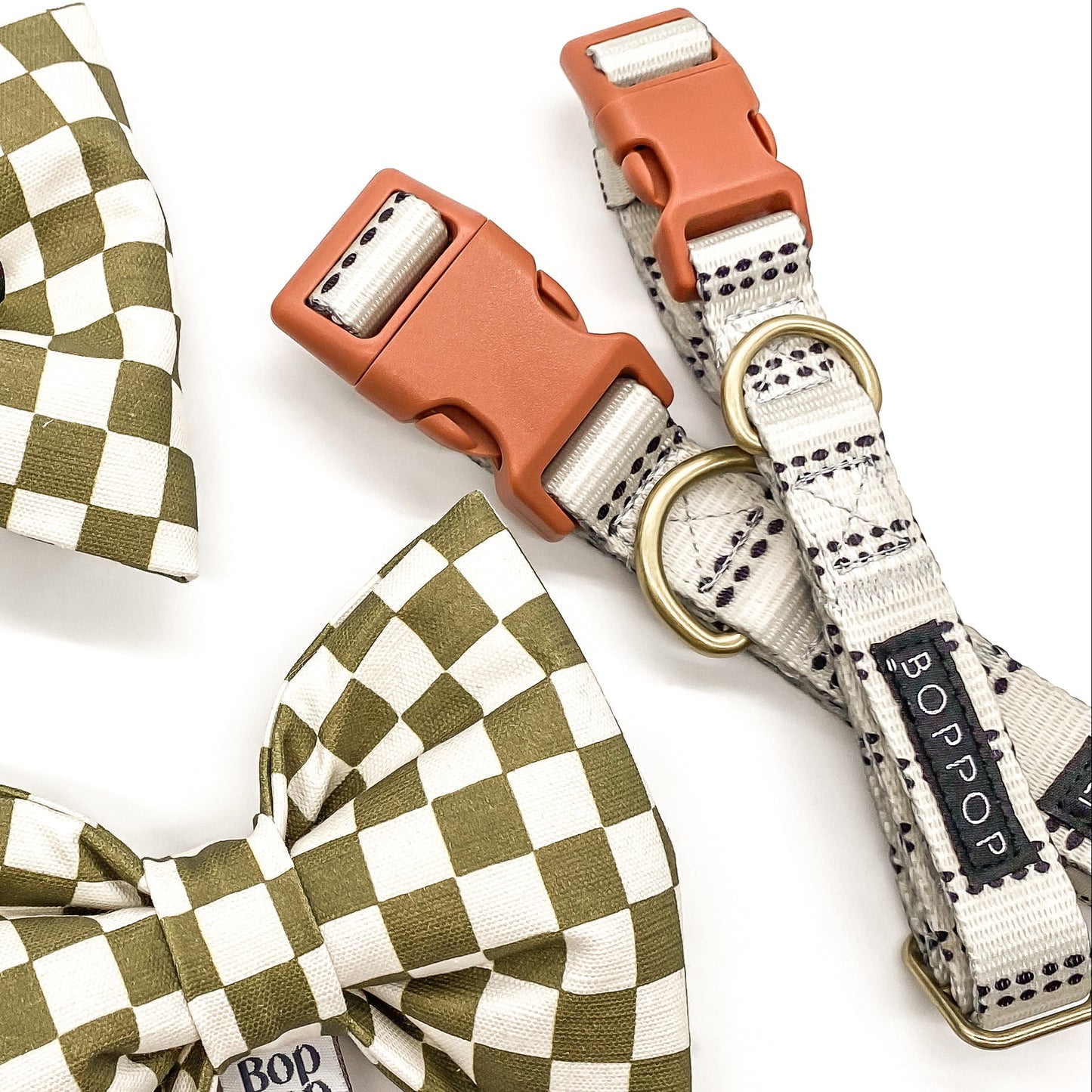 Olive green checkered bow ties and a dog collar with tags on a white background.