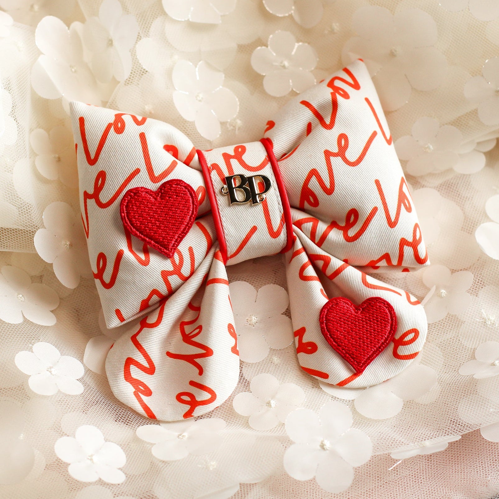 Bow with red hearts and 'love' text on a floral background