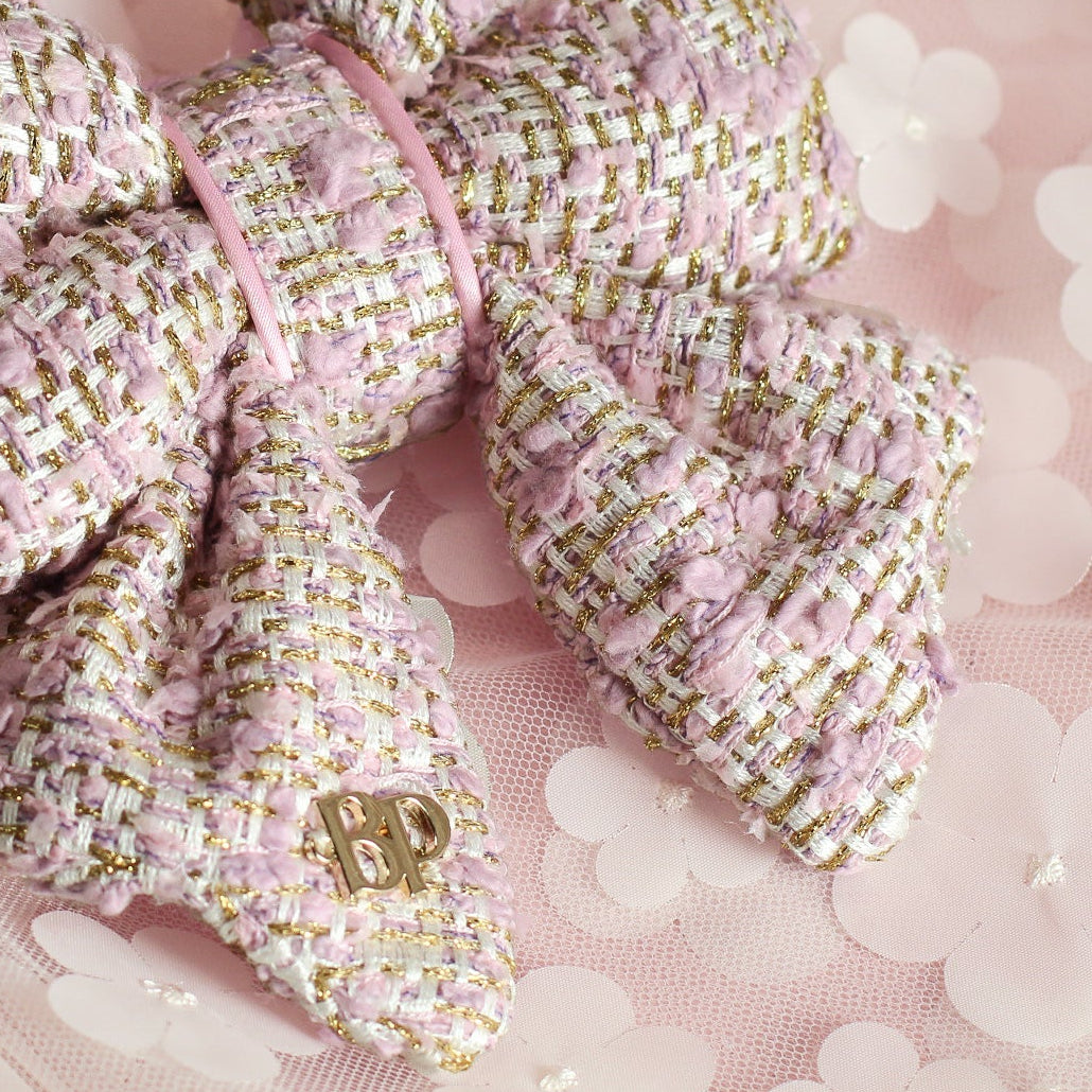 Pink and gold textured bow on a floral background