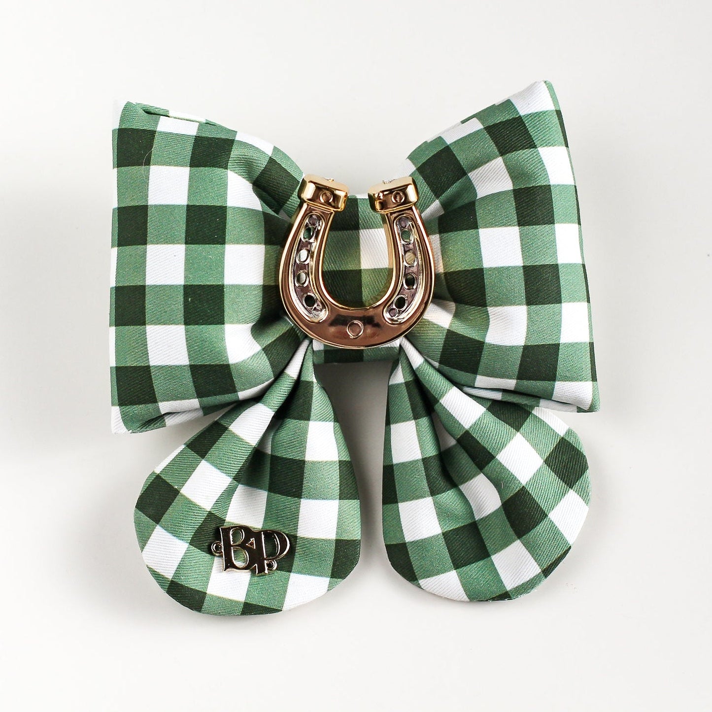 Green and white checkered bow with a gold horseshoe charm on a light gray background
