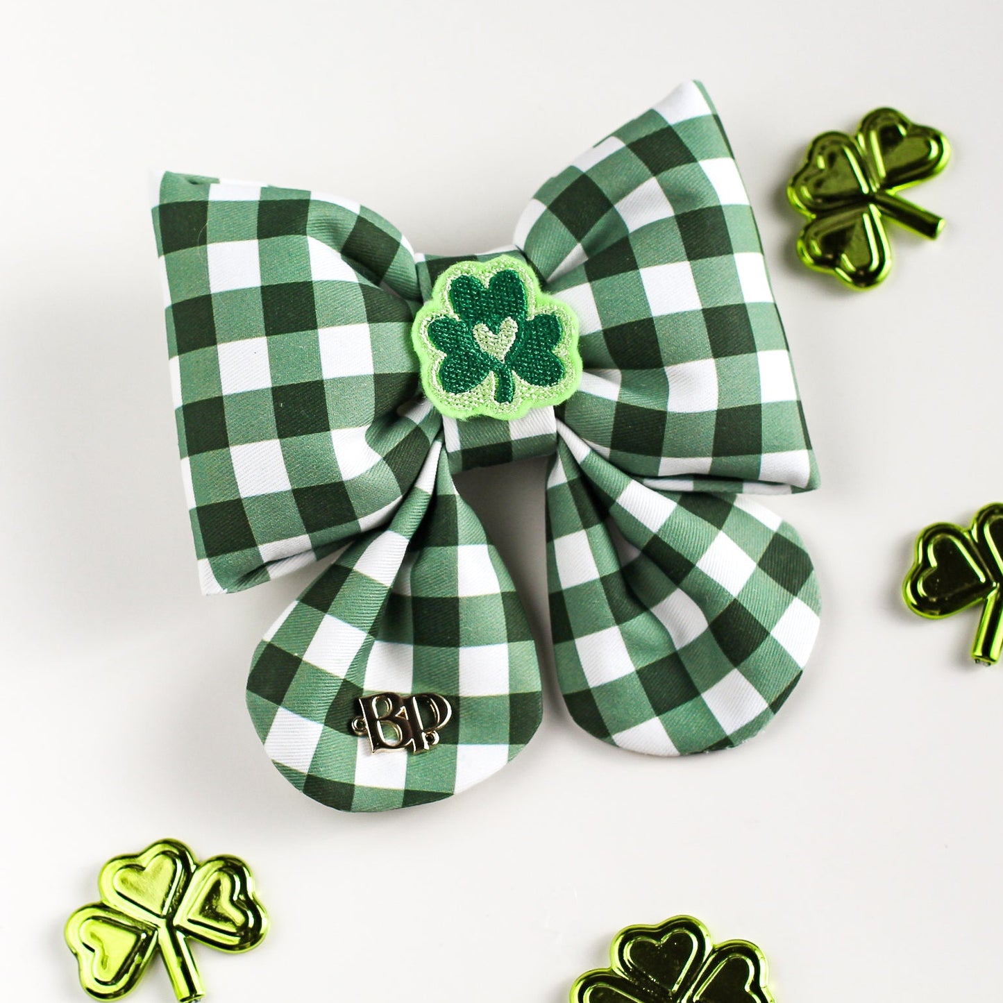 Green and white checkered hair bow with shamrock design on a white background