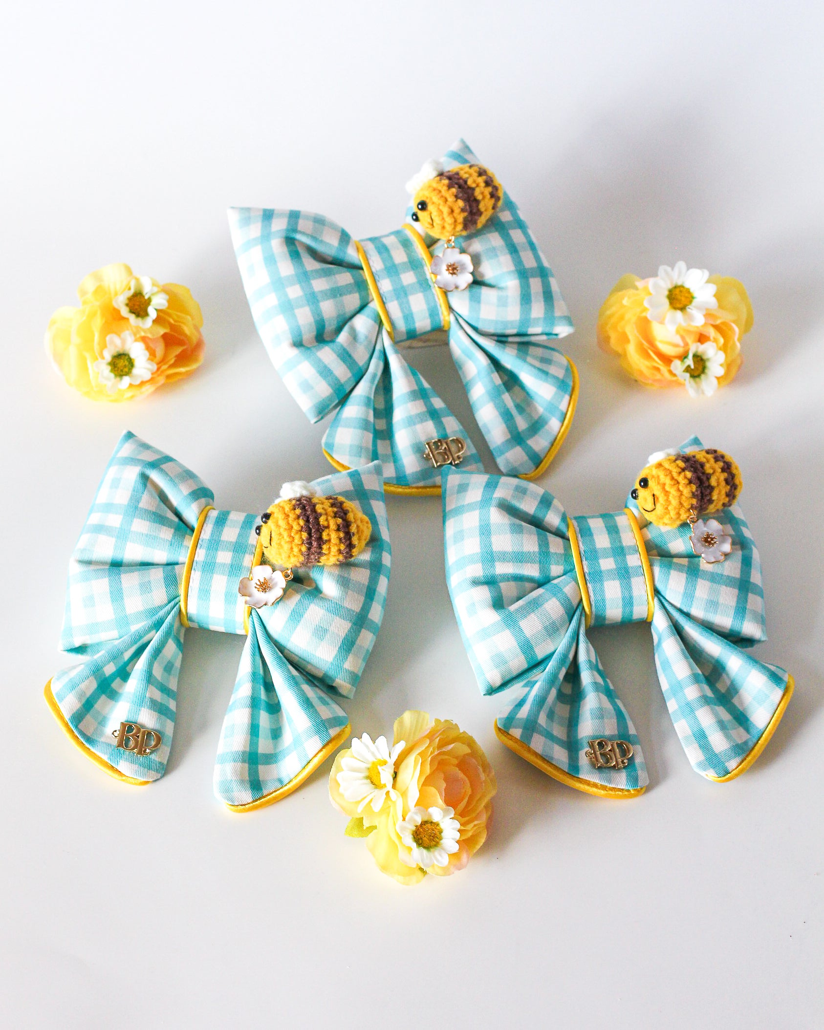 Colorful blue gingham sailor bow with crochet bee and metal flower daisy charm. Sailor bow for dog collars. Fashion dogs and dog mom style for beach summer style vibes. Hand made design with neon super bright summer florals with oranges. Cutest dog accessory for dogs and cats.
