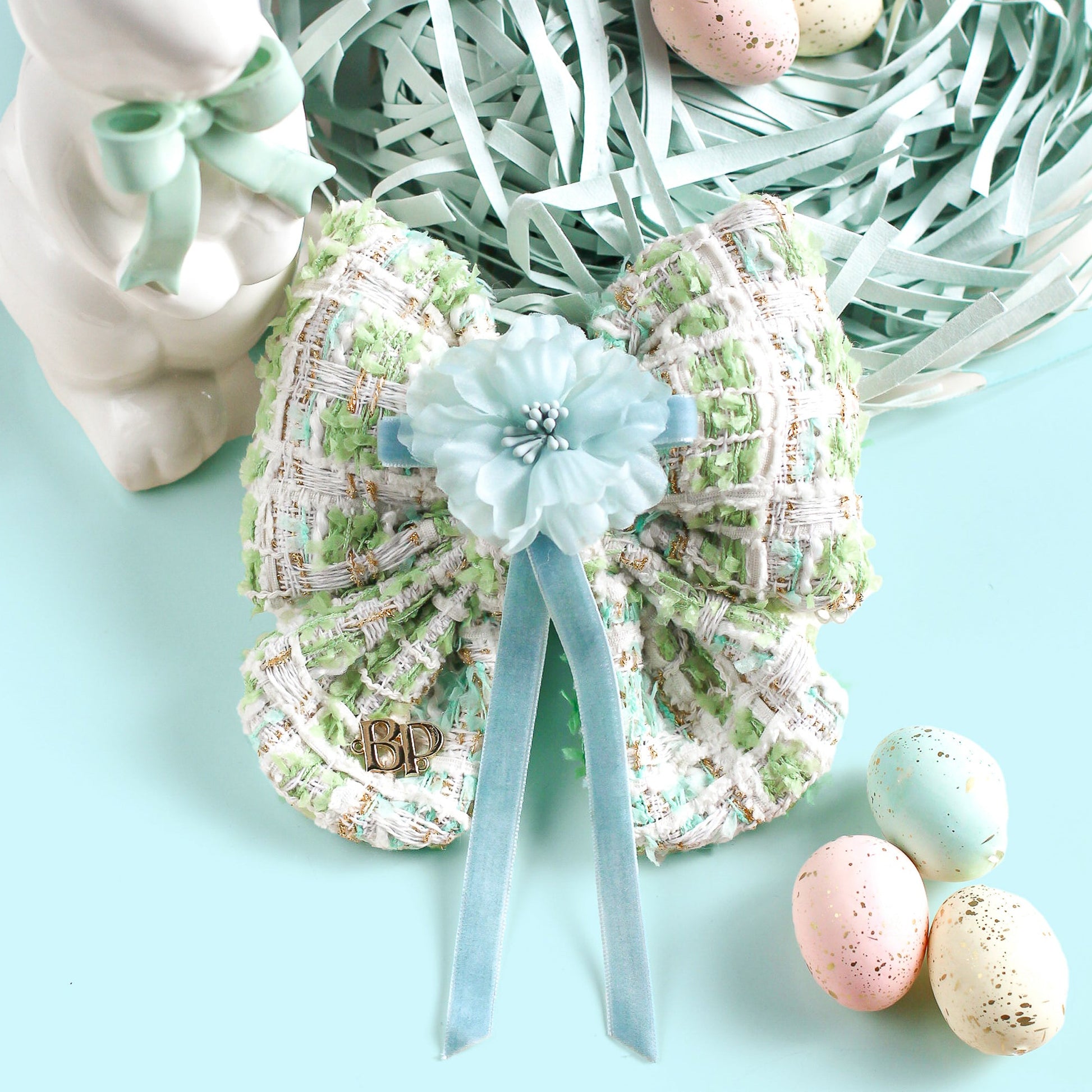 Decorative shoes with a bow and Easter eggs on a light blue background