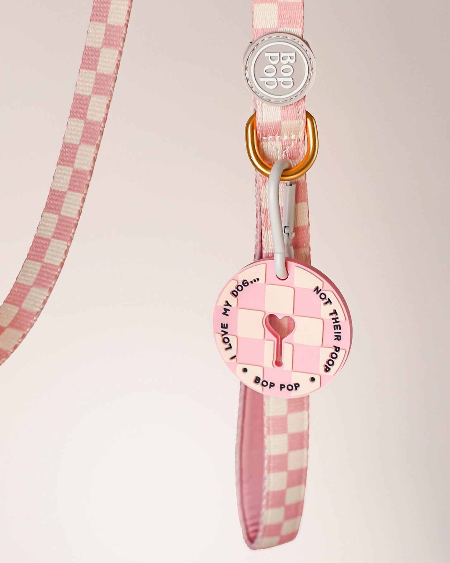Dog leash with Poop Loop for used dog waste bag. Pink checkerboard print with matching dog walking set by Bop Pop Pets