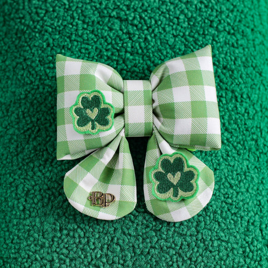 Green checkered bow with shamrock design on a green textured background