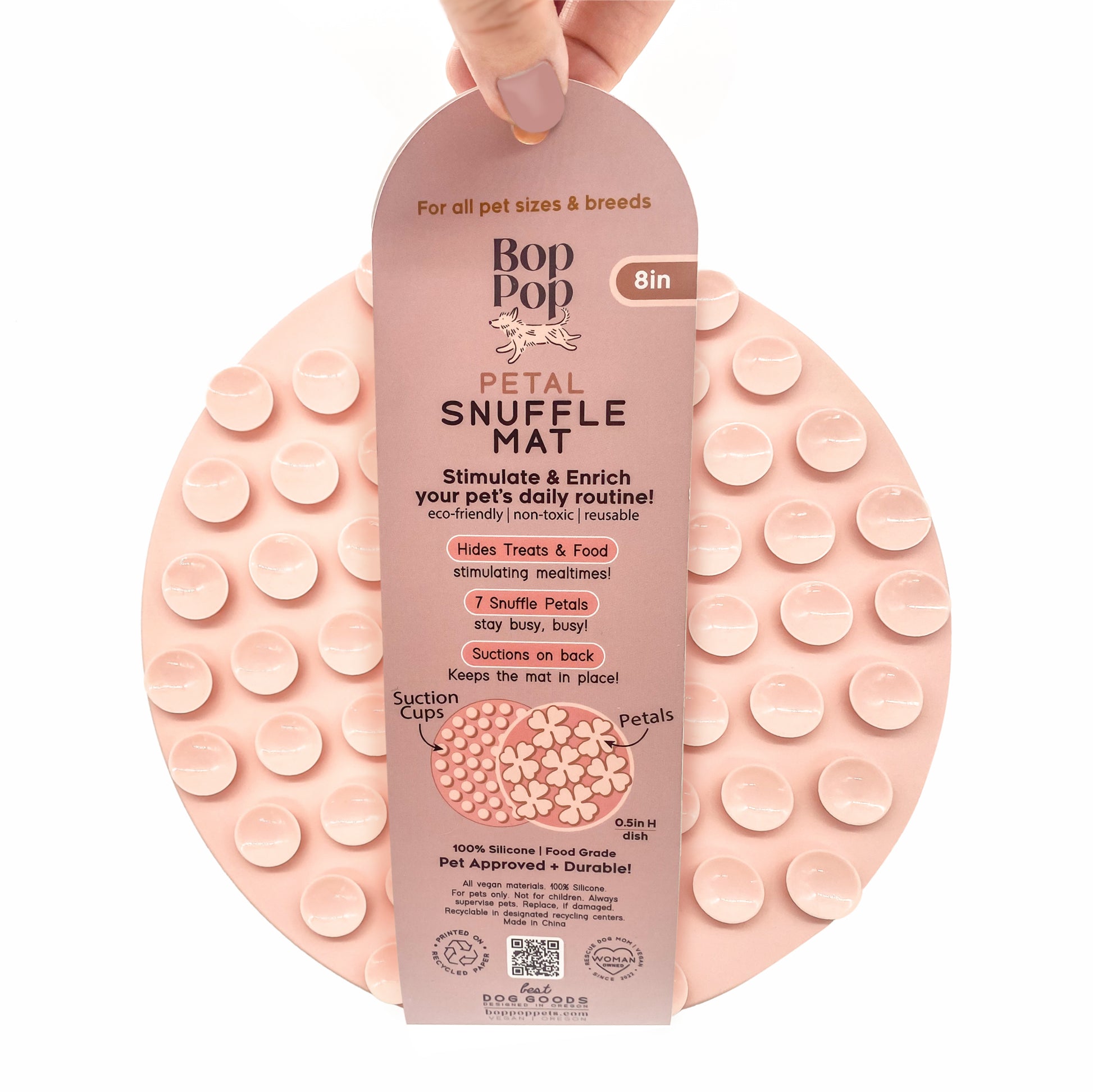 Snuffle Mat Blossom Rose Pink Silicone BPA Free slow feeder dog cat pet bowl mealtime enrichment anti-anxiety feeder featured on white background with hand holding the paper wrap showing backside circle suctions 