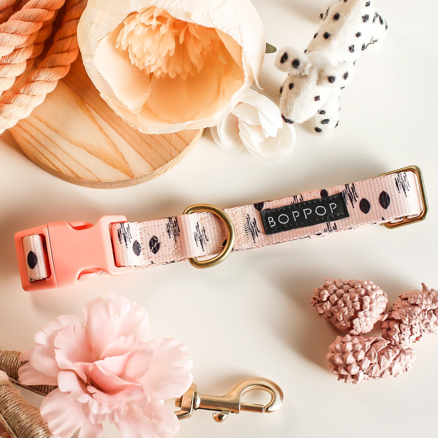 Dog collar with peachy pink floral pattern and 'BOP POP' branding on a light background with boho style