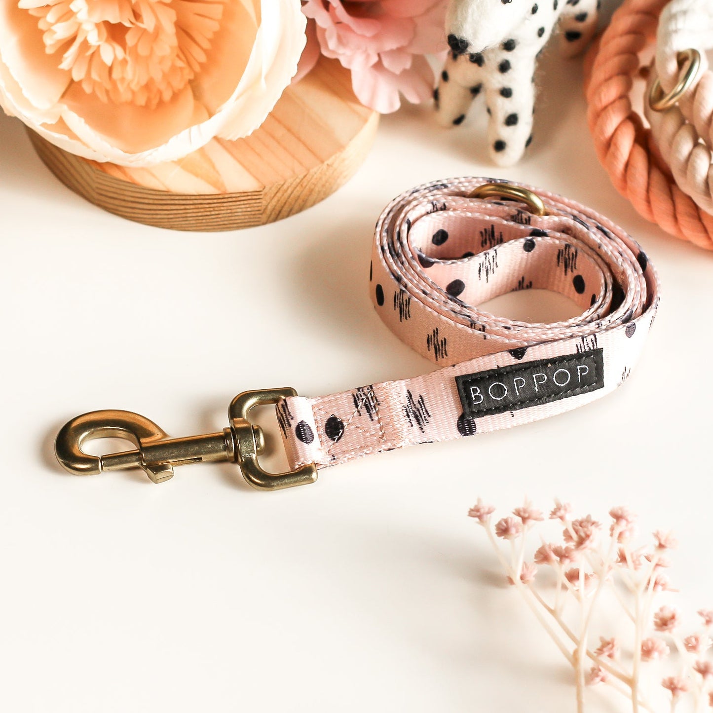 Dog leash with floral design and 'Boppy' branding on a light background with decorative elements.
