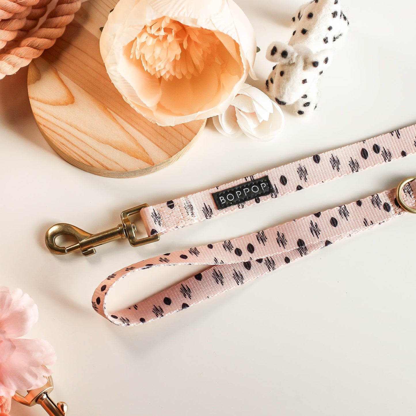 Dog leash with floral pattern and brand name on a light background