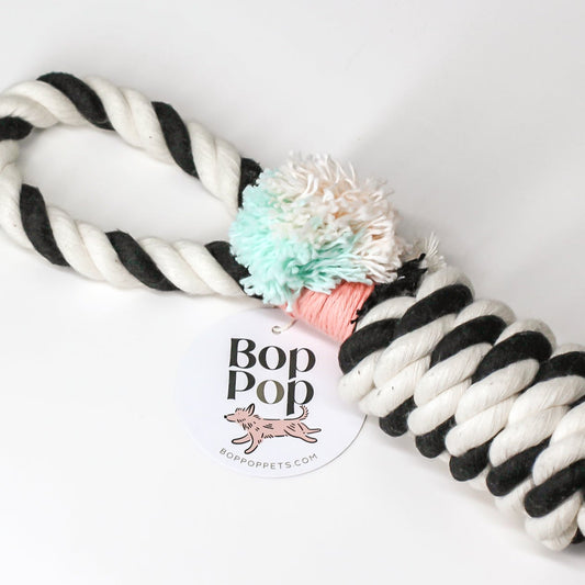 Tuggies dog toy made of 100% cotton rope. Twisted 2 color with handle, pom pom and fringe for interactive, stimulating playtime. Great for all size dogs small medium large. Hand made, tight twisted for tug & toss retrieve. Bop Pop Pets pet dog toy accessories.